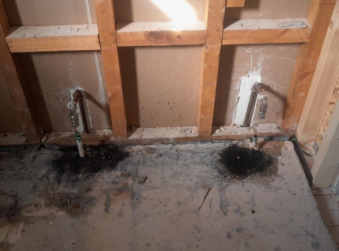 Rörkopplingar i en vägg, med märkta punkter och golvfästen. A och B är radiatoranslutningar, C och D är golvvärmeslangar. Underlaget är betong.