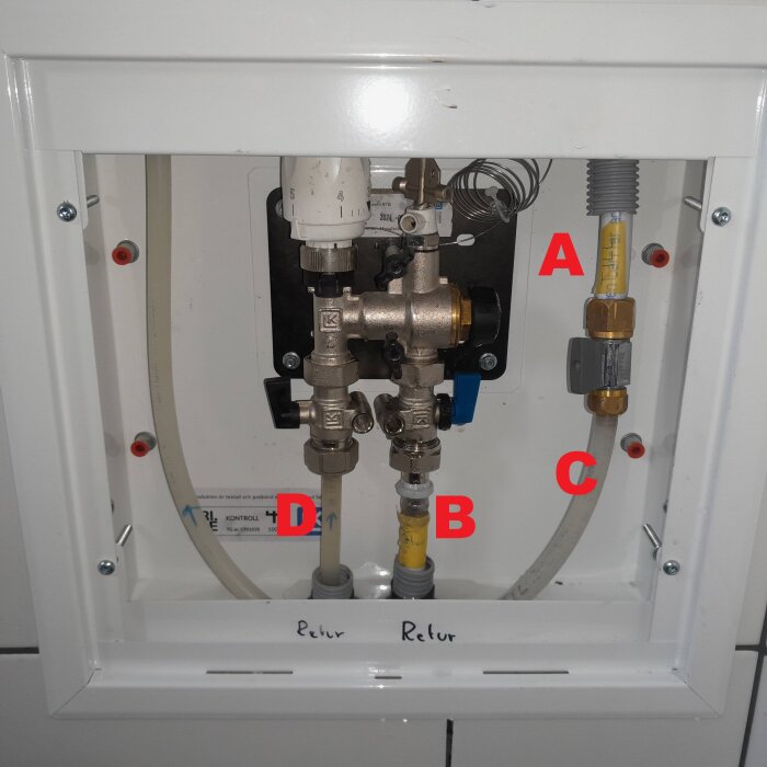 VVS-installation i skåp med märkta rör och kopplingar; A = Tillopp radiatorkrets, B = Retur radiatorkrets, C och D = Golvvärmeslang.