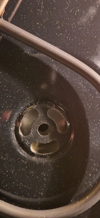 Ugnens tak med isoleringsmaterial som hänger ner i hålet, vilket orsakar partiklar att virvla runt vid användning av varmluftsfläkten.