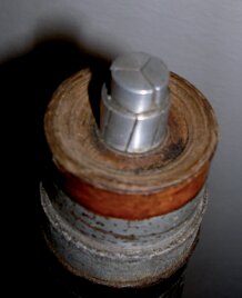 En tvärsnittsbild av en elektrisk kabel med silverfärgad ledare omgiven av isoleringslager i olika material, inklusive metall.