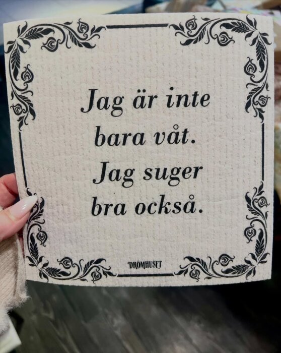 En disktrasa med texten "Jag är inte bara våt. Jag suger bra också" i dekorativ ram.