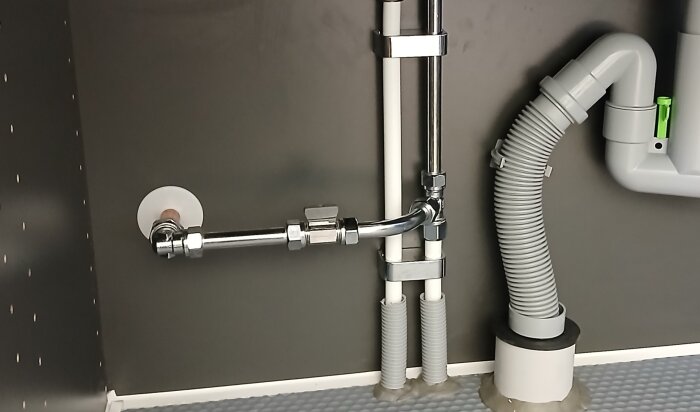 Rörinstallation med plastisolering under diskbänk, fokus på att minska kondens vid kyla.