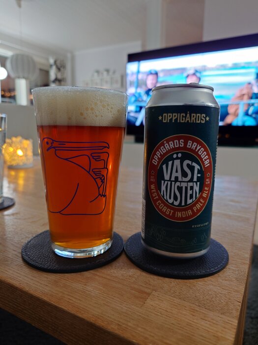 En ölburk med Oppigårds Västkusten West Coast IPA och ett full hällt glas bredvid i hemmamiljö.