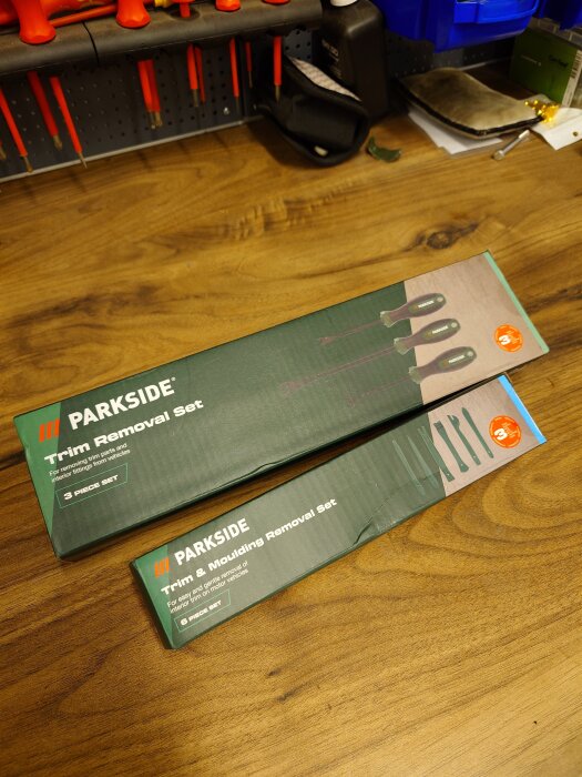 Verktygslådor med Trim Removal Set och Trim & Moulding Removal Set från Parkside på ett arbetsbord.