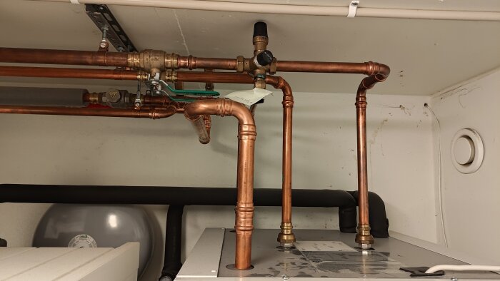 Kopparrör med ventiler i ett tekniskt rum. Ventilerna är anslutna i olika riktningar.