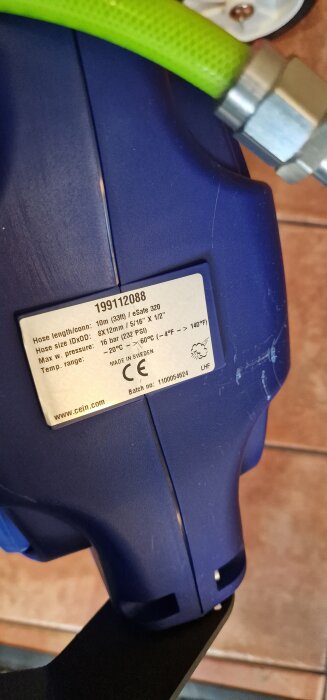 Närbild på Cejn automatisk slangvinda med grön slang ansluten, etikett visar specifikationer och CE-märkning.