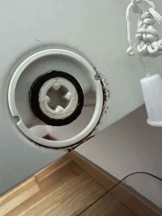Elementets bottenplugg med plastdel och rostbildning runt om.