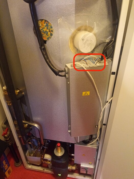Bygelförbindelse med ljusblå kabel mellan COM och S1 i ett värmesystem.