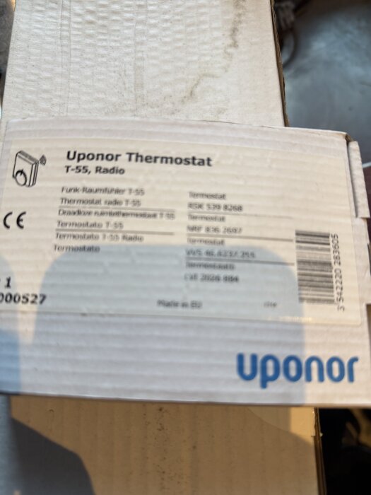 Förpackning med Uponor T-55 termostat, text och logotyp synliga.