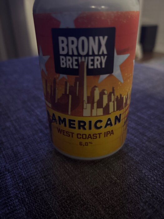 Burk med etikett för Bronx Brewery, American West Coast IPA, 6,0 % alkohol, mot en mörk bakgrund.