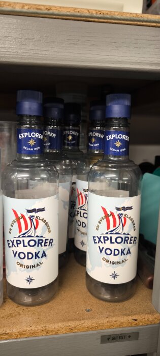 Flera flaskor Explorer Vodka på en hylla, med etiketter som visar segelbåt och texten "En svensk klassiker".