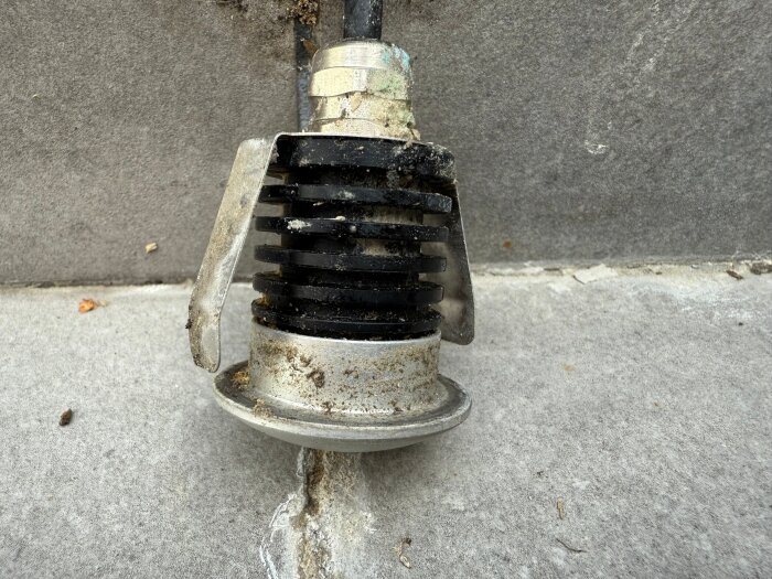 12V-spotlight för altantrappsteg, med avtagbar framsida, sliten och smutsig, ligger på betongyta.
