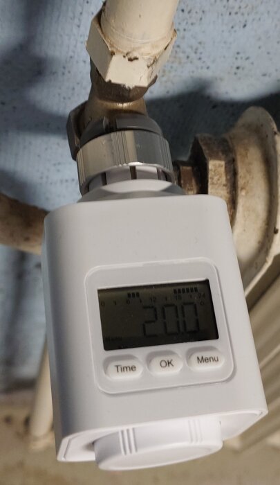 Lidl-termostat monterad på gammalt Danfoss ventilhus i tvättstugan, visar 20.0 grader på displayen.