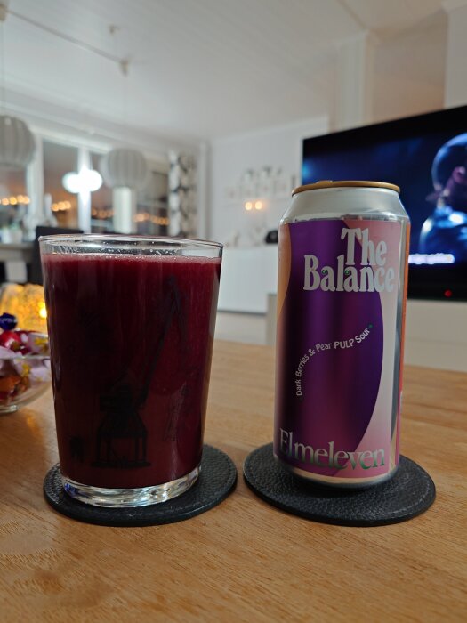 En burk och ett glas med Elmeleven souröl på ett bord i ett vardagsrum.