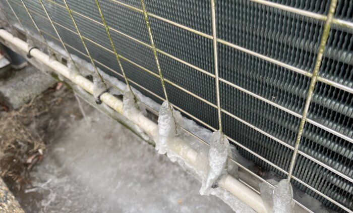 Is och frostbildning på värmepumpsrör omgiven av metallnät vid Nibe Fighter 2010.