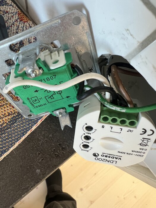 Elektrisk installation visar en dimmer med flera anslutna kablar och märkning.