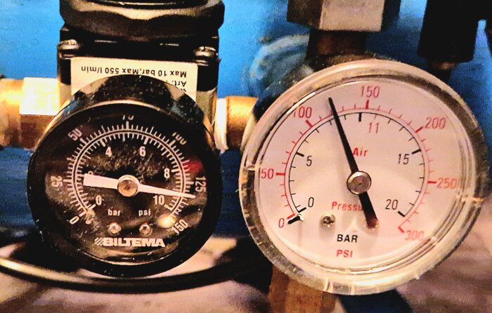 Två manometrar på en kompressor visar tryck. Den vänstra mäter upp till 10 bar och den högra upp till 300 PSI.