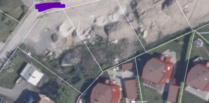 Satellitbild över bostadsområde med tak i rött, gator och ofärdig tomt markerad med texten "Ångeslupsvägen".
