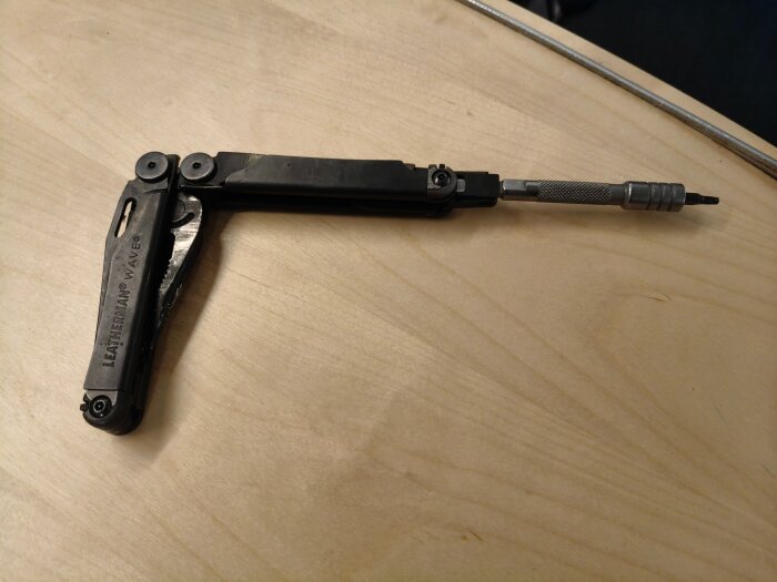 Leatherman Wave med bitshållare i 90 graders vinkel på ett träbord.