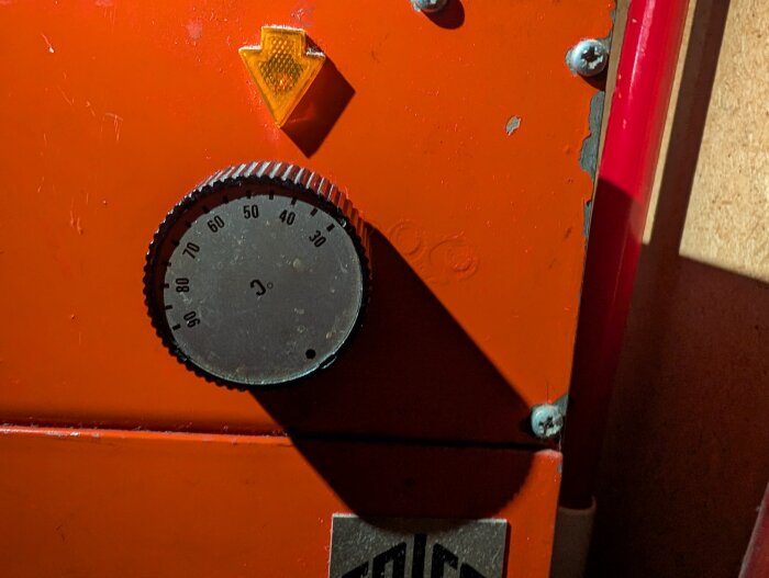 Orange värmepanna med termostat vridreglage och temperaturinställningar från 0 till 90 grader.