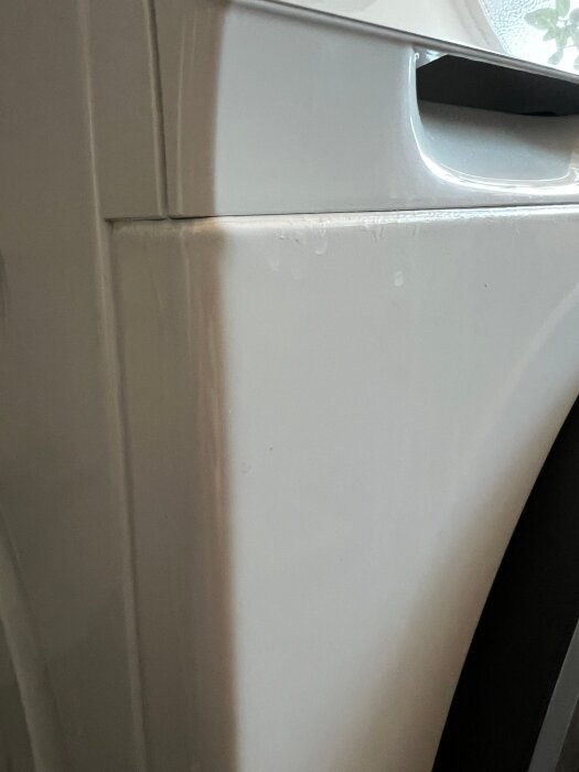 Närbild av en tvättmaskin där det syns fukt eller ringar av torkat vatten kring doseringsfacket.