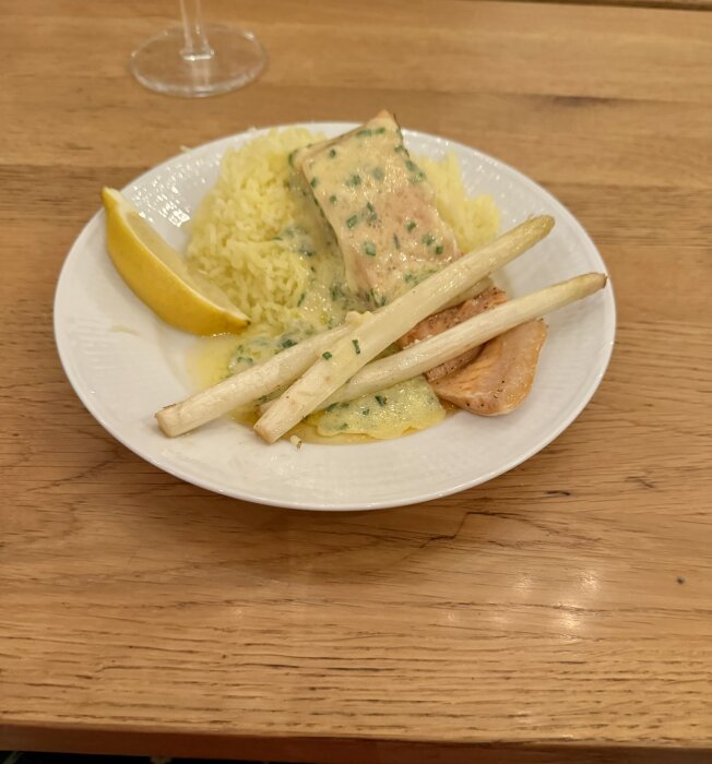 En tallrik med regnbågsfilé, vit sparris, pressad potatis och en citronklyfta, toppad med sås som försökte bli en beurre blanc.