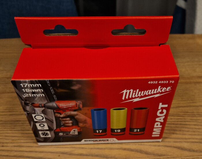 Milwaukee Impact hylsor i paket, inkluderar storlekarna 17mm, 19mm, och 21mm. Rött paket på ett träbord.