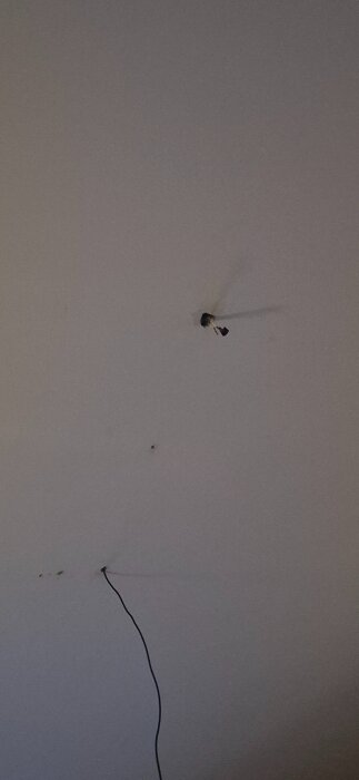 Tak med hängande svart sladd, för tillfällig kamera, där lampa planeras.