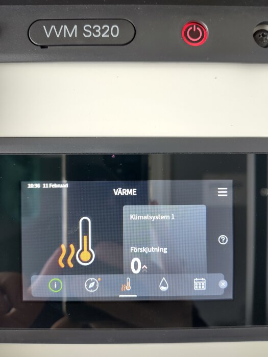 Display på värmesystem VVM S320 visar klimatsysteminställningar med lufttemperatursymbol och förskjutning på noll, avfrostningslarm lyser.