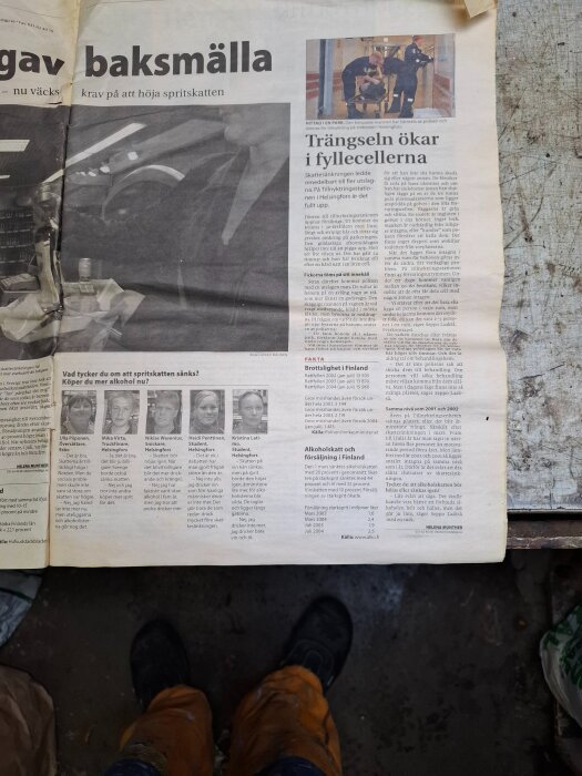 Tidningssida från Göteborgs-Posten 2004 med rubriken om baksmälla och alkoholskatt; arbetsbyxor och skor syns delvis i bildens nederkant.