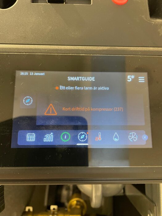 Display på värmepump med varning om kort drifttid på kompressor och flera aktiva larm. Temperaturen visas som 5 grader.