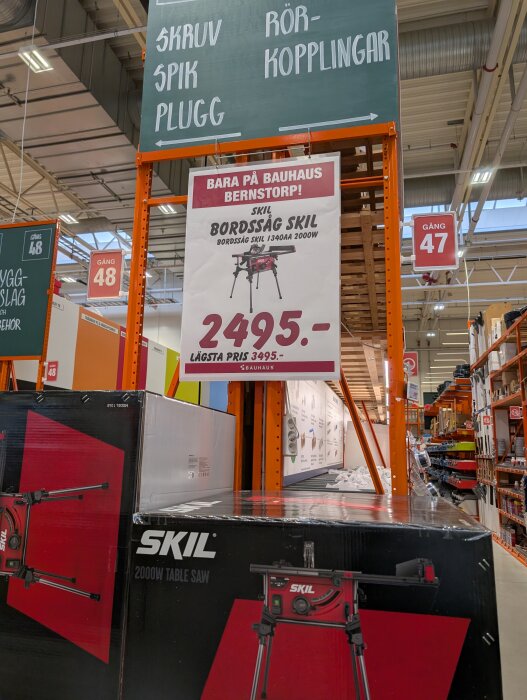 Bauhaus med erbjudande på Skil bordssåg för 2495 kr, skylt och förpackningar i gång 47-48 med rörkopplingar och skruvar i närheten.