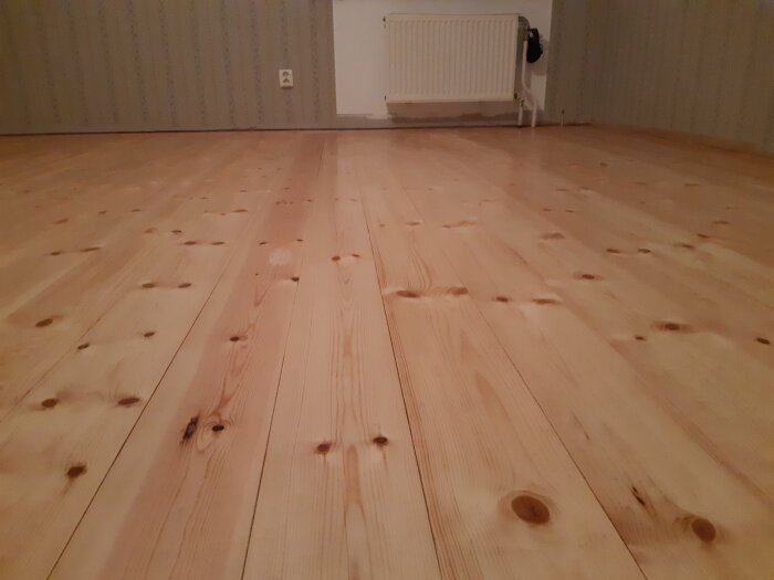 Nybehandlat furugolv med sidenmatt Osmo, nylagt och slipat efter renovering med riktat bjälklag och kompletterad isolering i ett rum.