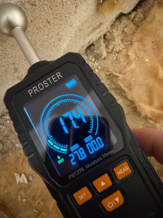 Fuktmätare visar 174 på en torrare yta efter golvrenovering, arbetet innefattar dränering och avlägsnande av gammal isolering från 60-talet.