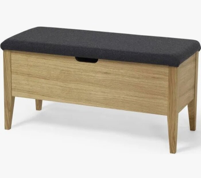 Träbänk med grå vadderad sits och förvaring under.