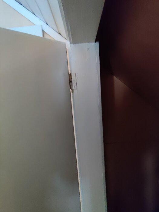 En gammal garderobsdörr med synligt gångjärn och karm i behov av renovering, del av ett projekt med specialanpassade dörrar.