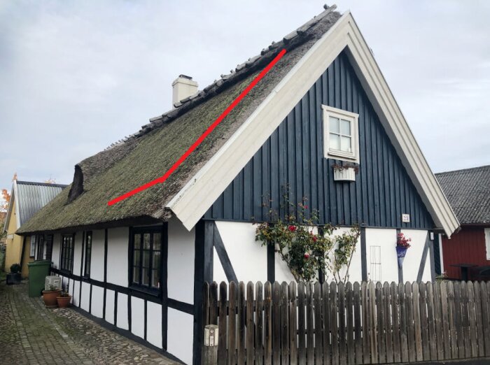 Byggnad med halmtak, plankstaket, fönster och markerad linje på taket för att illustrera förlängning av takfot enligt inläggsbeskrivningen.