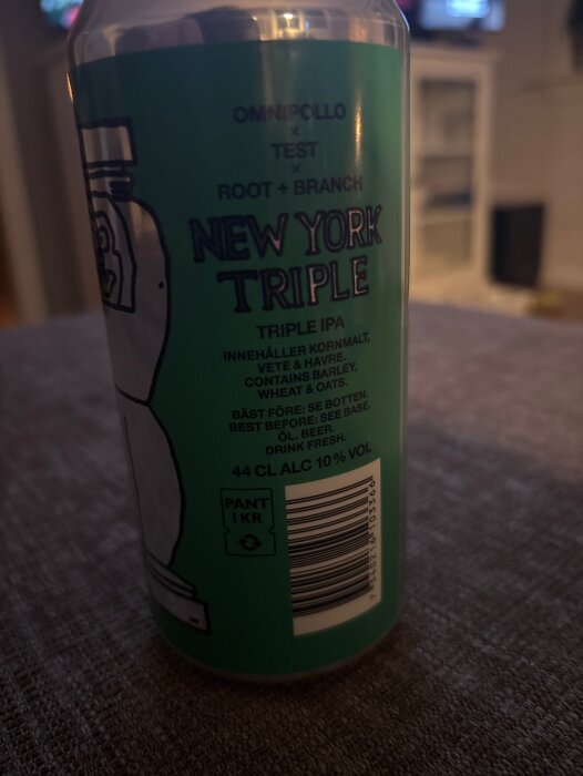 Burk med öl av märket "New York Triple" Triple IPA från Omnipollo. Etikett informerar om innehåll och alkoholhalt, 10%.