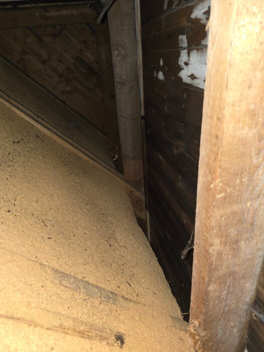 Bilden visar en kallvind med träkonstruktion i ett äldre hus, där mikrobiell tillväxt och bristfällig ventilation ses som problem.