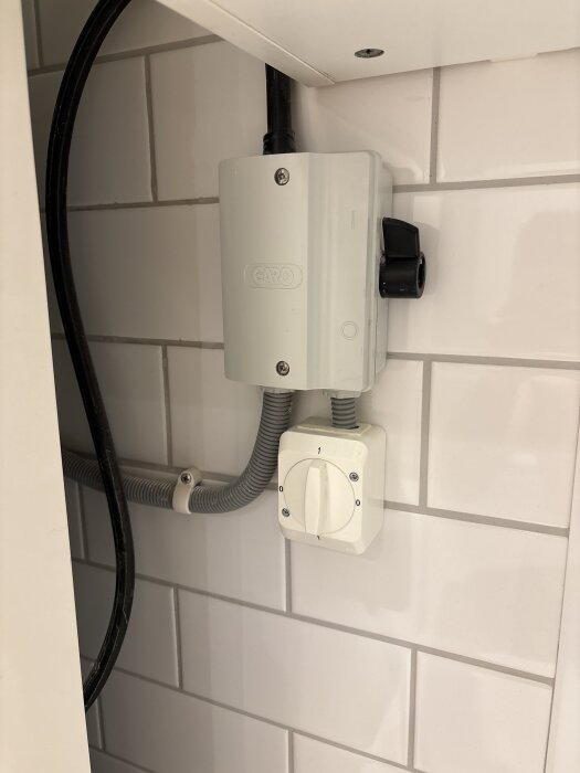 Reglage och kablar på Nibe EVC13 panna mot kakelvägg.