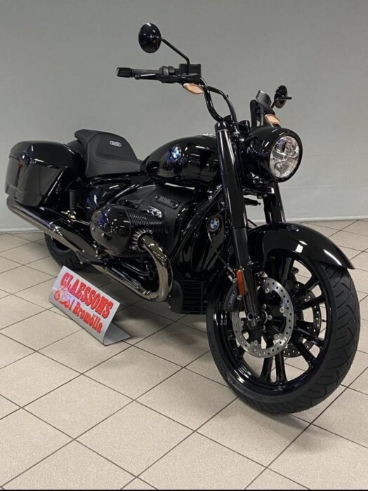 Svart motorcykel av modell Roctane MY24 från 2023, står på ett utställningsgolv hos en motorcykelåterförsäljare.