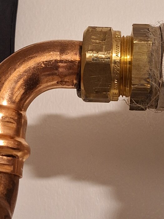 Kopparrör med mässingskoppling, tecken på läckage runt anslutningen.