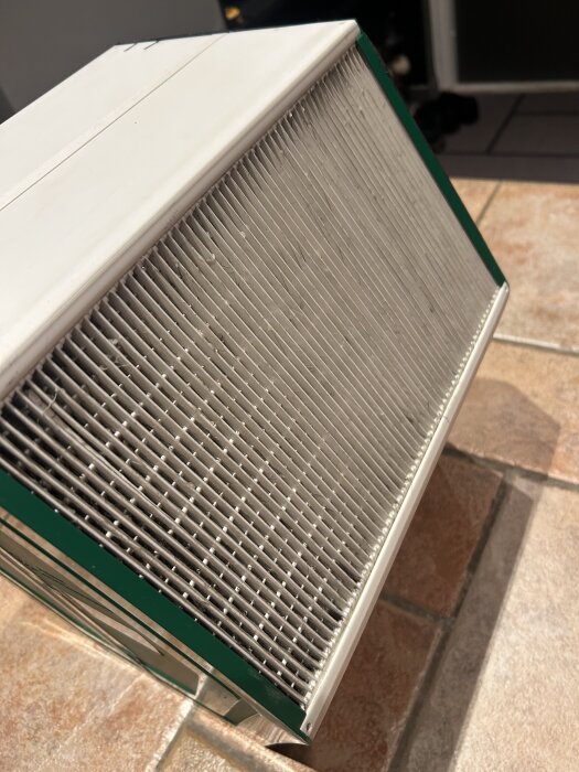 Ventilationsaggregat med ett rent filter syns nära fotat. Aggregatet är del av en diskussion om rengöring och byte av givare.