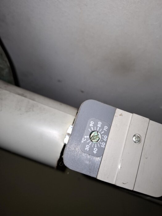 Temperaturmätare på ett rör, inställt på cirka 75 grader, del av ett värmesystem kopplat till ackumulatortank och panna.