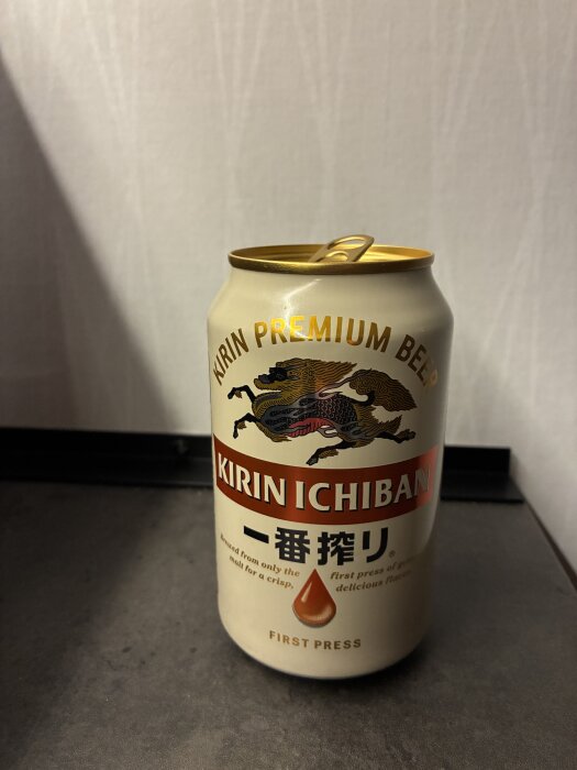 En burk Kirin Ichiban öl med en drake avbildad på etiketten, ståendes på ett bord.