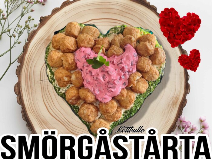 Hjärtformad smörgåstårta dekorerad med köttbullar och rosa fyllning, omgivet av blommor och röda hjärtan.