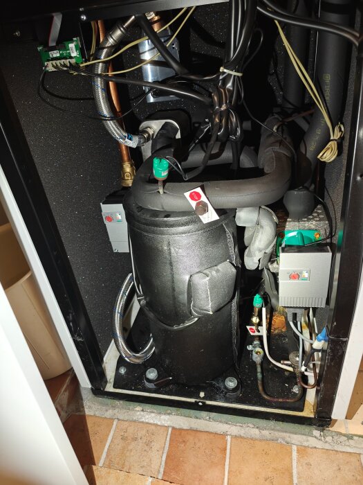Elektronikpanel inuti en maskin, med kablar och komponenter synliga, inget bränt eller trasigt.