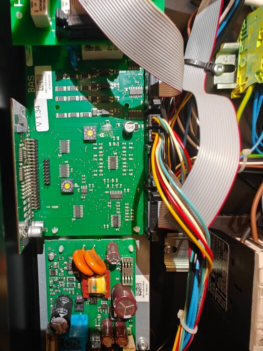 Närbild på elektronikkort med flera komponenter, inklusive kondensatorer och kablar, inget tecken på brännmärken eller skador.