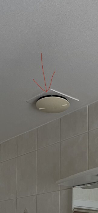 Takmonterad ventilplatta, markerad med röd pil, ovanför kaklade väggar. Fråga om material: eternit, metall eller hård plast.