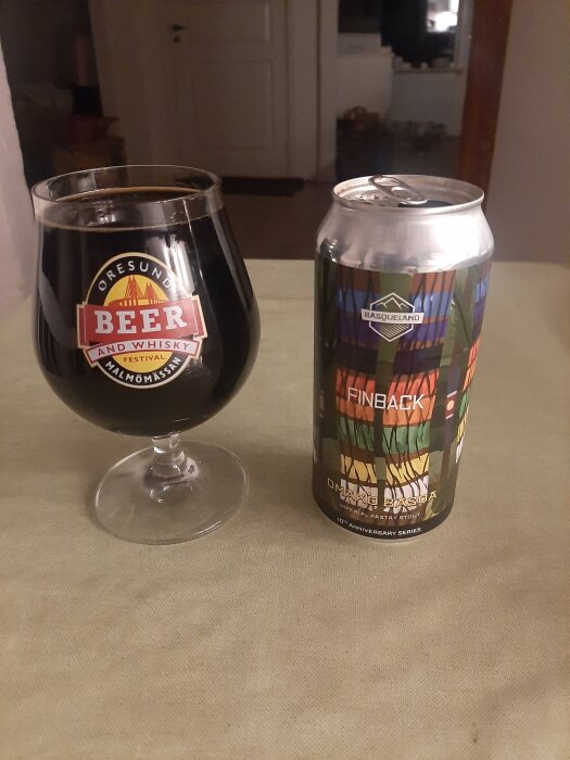 Ett glas dark beer och en burk Pastry Stout från Basqueland på ett bord.